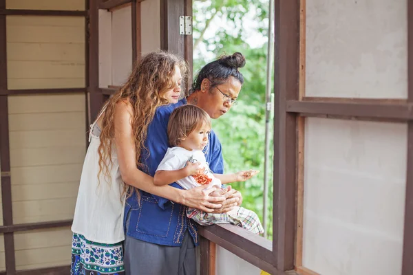 Famille regardant par la fenêtre — Photo