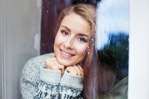 Beautiful young woman  behind the glass — Stock Photo, Image