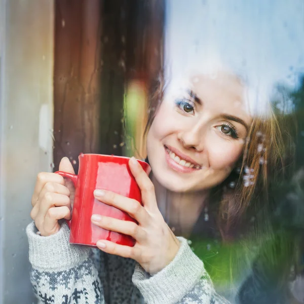 Vrouw achter het venster genieten van koffie — Stockfoto