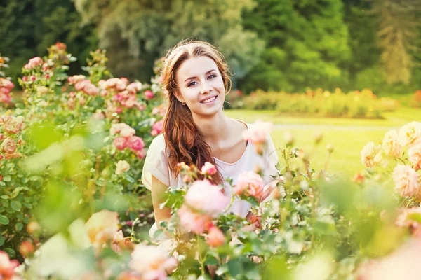 Mujer en un jardín de rosas — Foto de Stock