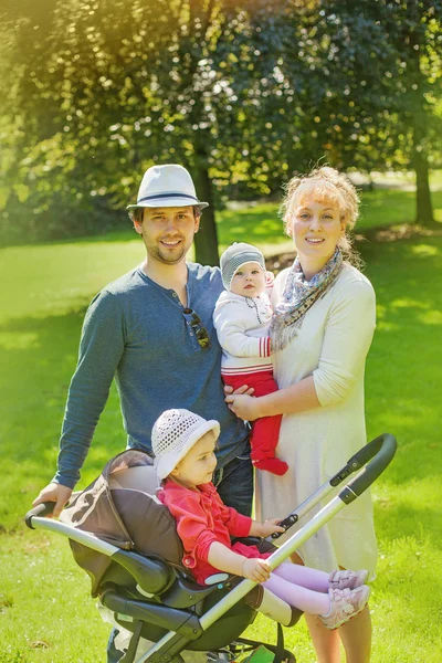 Rodina s dvěma dětmi v parku — Stock fotografie