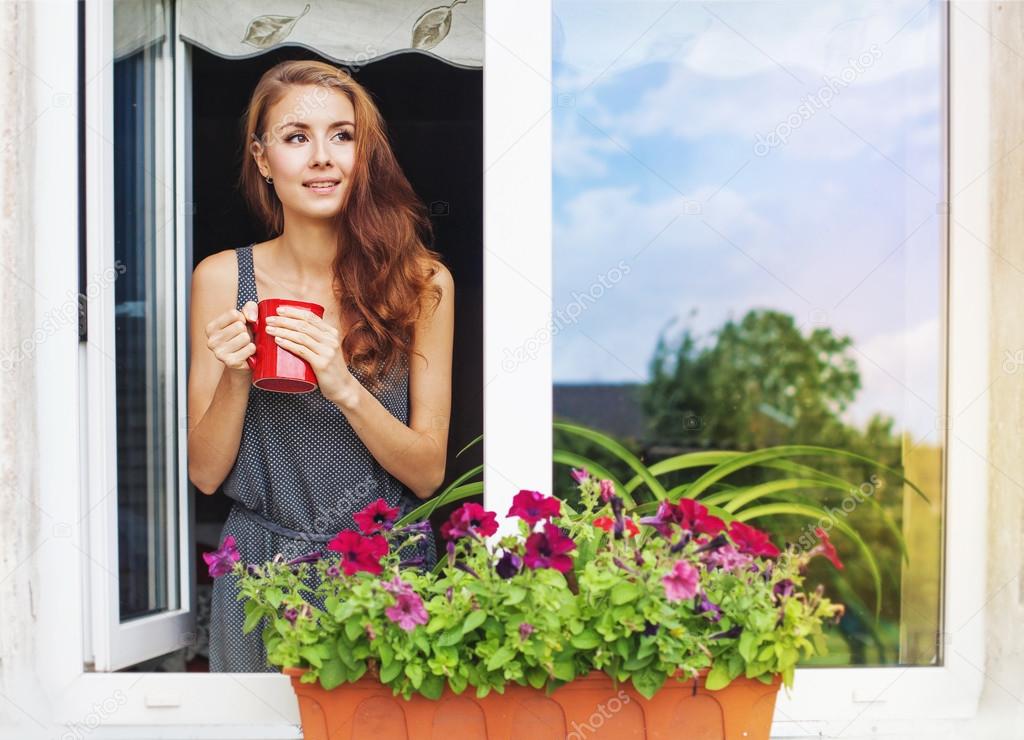 Woman on a balcony enjoying morning coffee