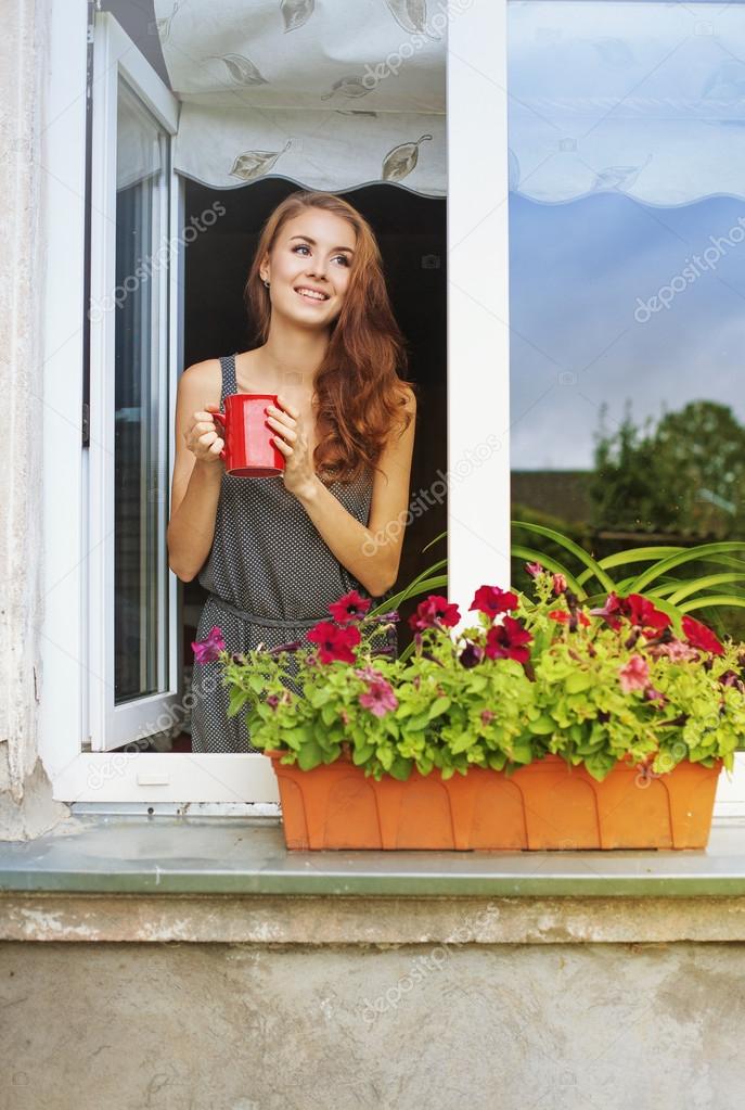 Woman on a balcony enjoying morning coffee