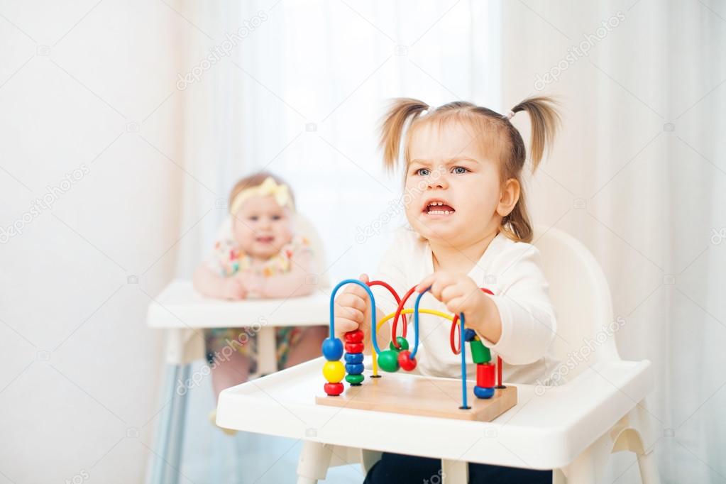 Two little girls in highchairs