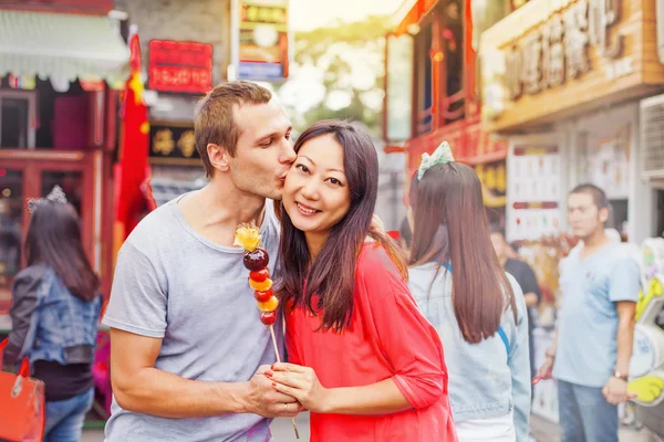 用一根棍子上的食物混合的种族的夫妻 — 图库照片