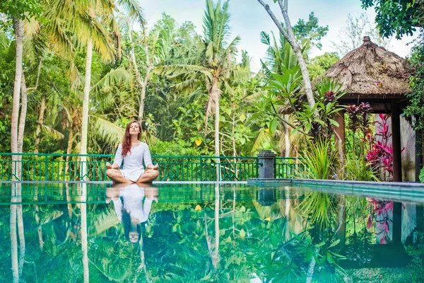 Woman meditating at pool side. — Stock Photo, Image