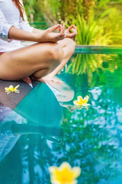 Mujer meditando al lado de la piscina . — Foto de Stock