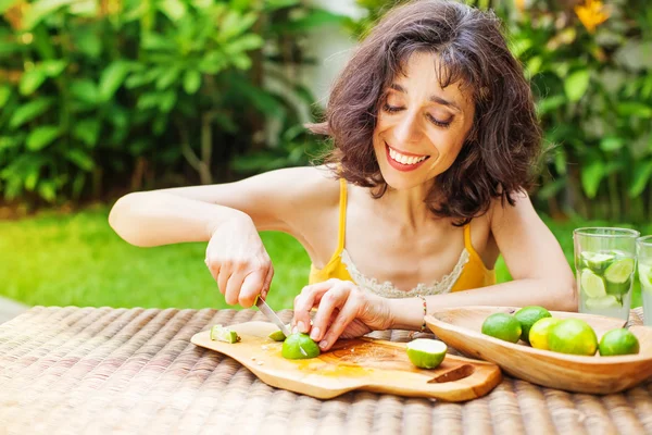 Woman doing cocktail with limes — Stock Photo, Image