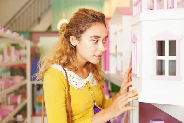 Mujer comprando una casa de juguete — Foto de Stock