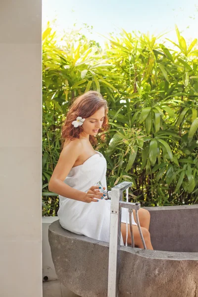 Donna seduta sul bordo di un bagno — Foto Stock