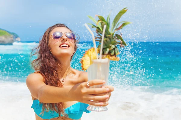 Frau hält einen Cocktail am Strand — Stockfoto