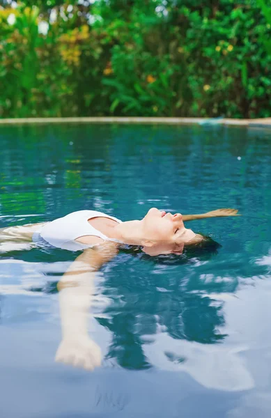 Woman dives in swimming pool — Stock Photo, Image