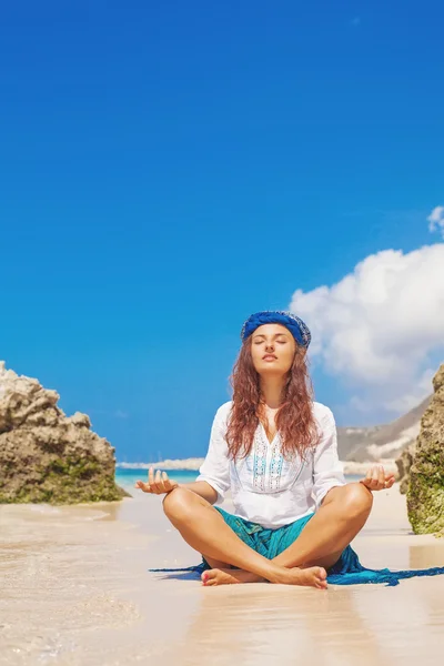 Vrouw mediterend op het strand — Stockfoto