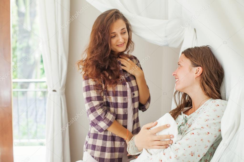 Sister visiting a  mother with her newborn