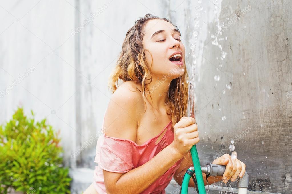 Woman drinking from a hose