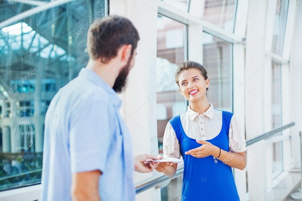 Flight attendant checking documents of  tourist