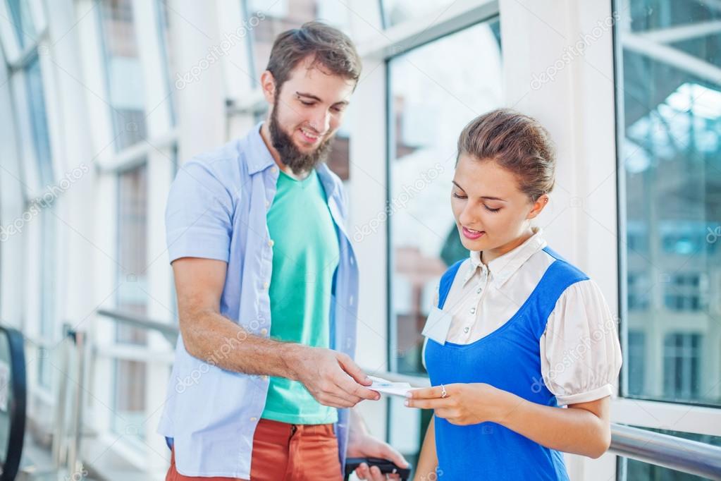 Flight attendant checking documents of  tourist