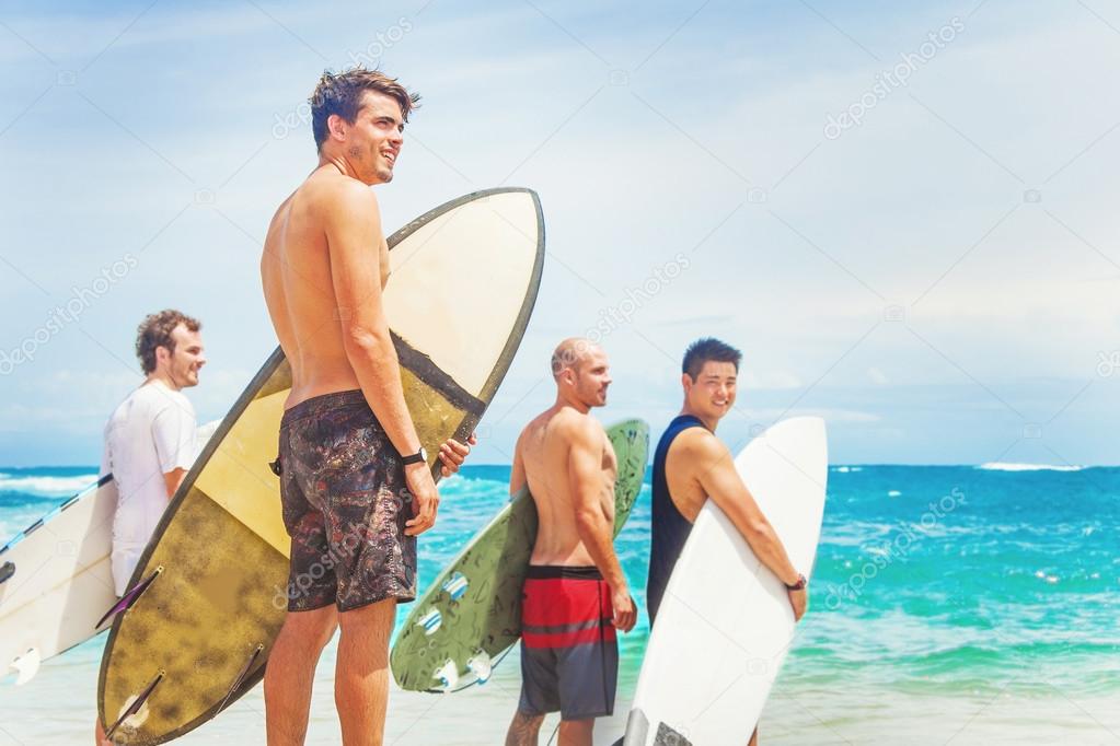 group of surfers on a beach