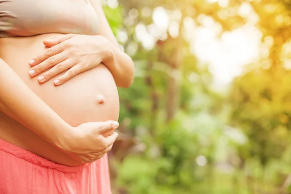 Schwangere berührt ihren nackten Bauch — Stockfoto