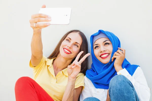 Mujeres usando el teléfono juntos — Foto de Stock