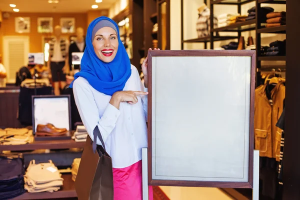 Muslimsk kvinna som pekar på en tom platta — Stockfoto