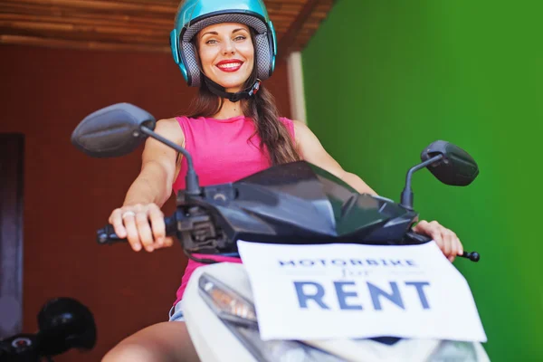 Mulher levando uma moto para alugar — Fotografia de Stock