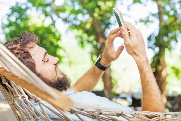 Hamakta cep telefonu kullanan adam — Stok fotoğraf