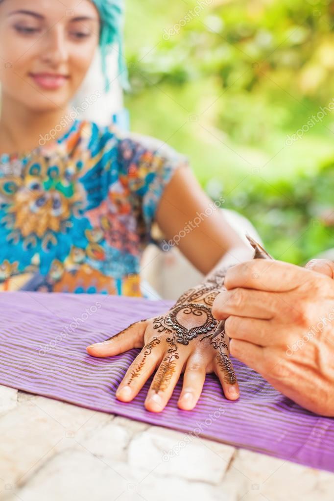 hand drawing henna tattoo