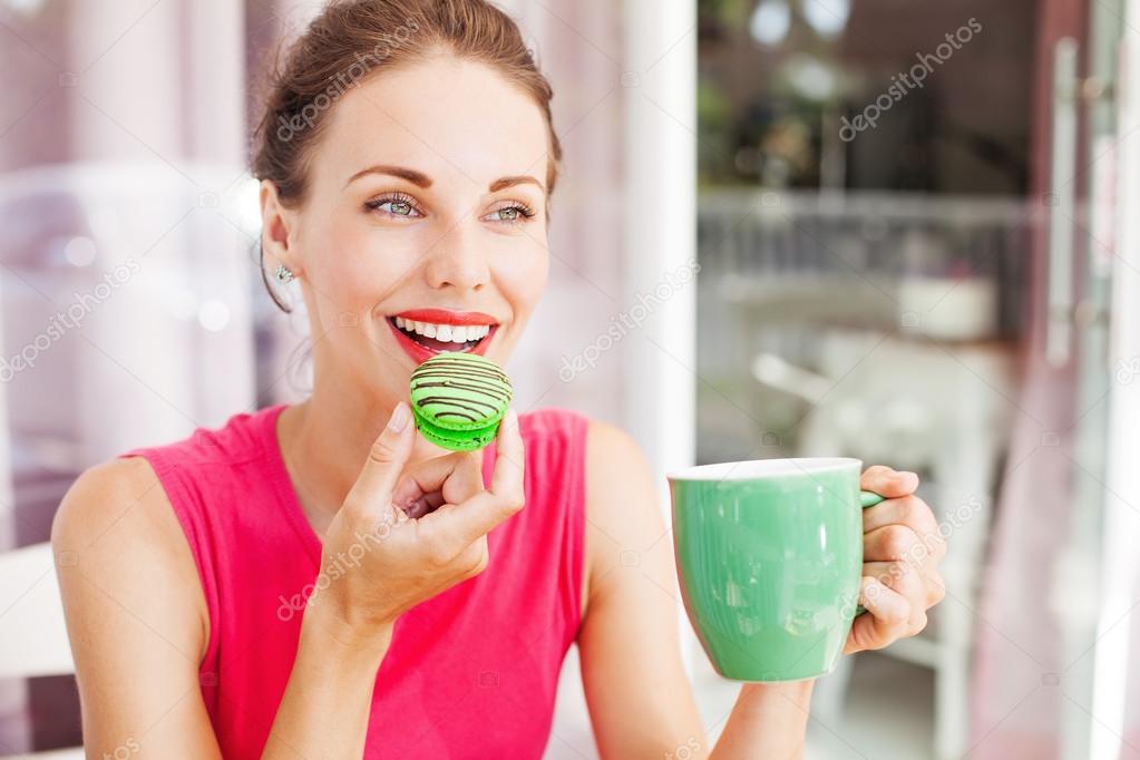 woman with macaron and cup of coffee