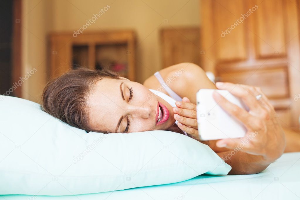Woman using  phone as alarm clock