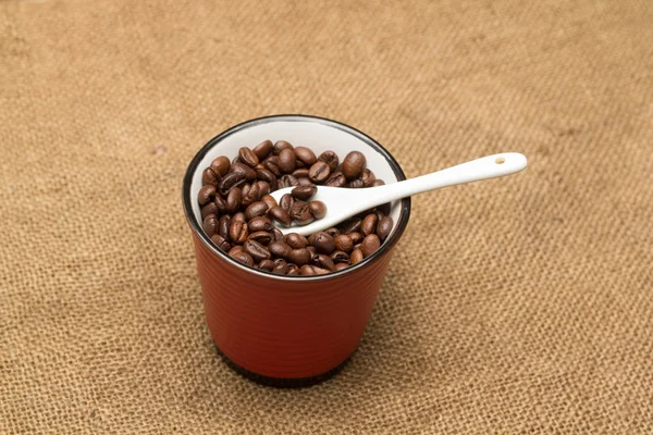 Een kopje met koffie bonen — Stockfoto