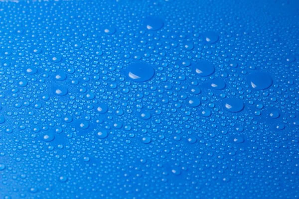 Gota de água em uma superfície azul — Fotografia de Stock