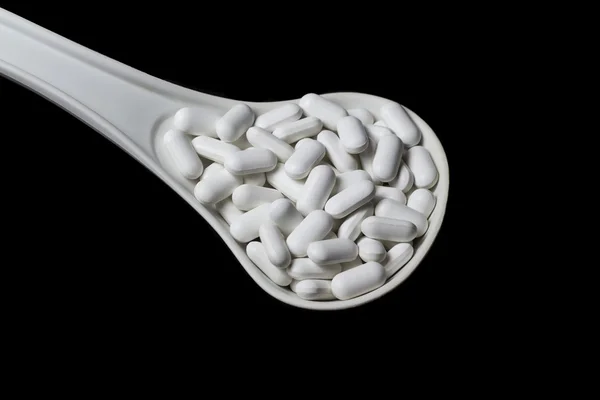 Łyżka białego z białe tabletki — Zdjęcie stockowe