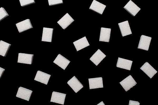 Klumpen Zucker auf schwarzer Oberfläche — Stockfoto