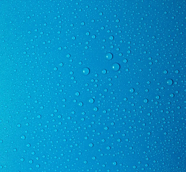 Gotas de água em uma superfície azul — Fotografia de Stock