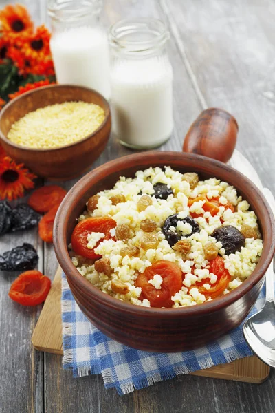 Millet porridge with dried apricots and prunes in a bowl — Stock Photo, Image