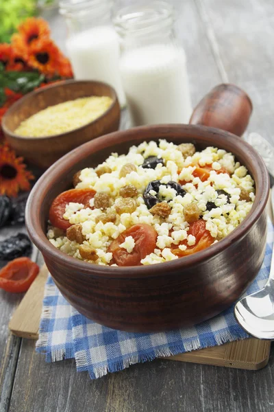 Porridge de millet aux abricots secs et pruneaux dans un bol — Photo