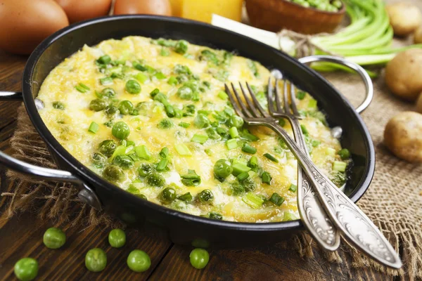 Омлет с зеленым горохом, картофелем и сыром — стоковое фото