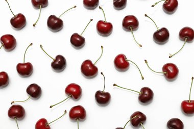 Olgun, lezzetli kirazlar kaotik bir sırayla beyaz bir arkaplanda, insanların arka plan resmi olmadan dağıtılmış.