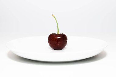 Beyaz bir porselen kasede, insansız kırmızı kiraz çileği.