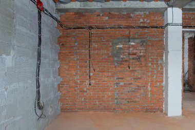 Yeni bir ev inşaatı, duvarlara elektrik kabloları döşenmiş.