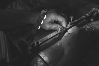 Efendinin elleri. Atölye çalışması, bir matrisin üretimi ve geliştirilmesi, karton ve kağıt kapları kestiği için ölüyor. Metal işçisi. El yapımı. Uzayı kopyala Siyah ve beyaz