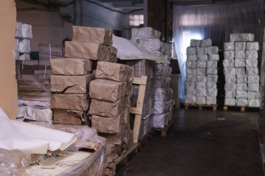 Kutularla dolu paletler, ürünler kağıtlara dolduruluyor ve bitmiş eşya deposunda yığılıyor. Karton fabrikası konsepti. Seçici odak