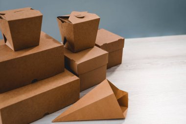 Farklı tipte kahverengi karton ambalajlar. Fast food, katlama, büyük ve küçük için. Kağıt ürünlerinin üretim ve tasarımı kavramı. Mesaj için yer. Seçici odak.