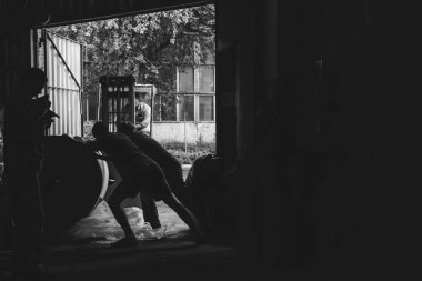 İşçiler, yükleyici. Sıkı çalışma. Depodaki malların kabulü. Sanayi, kağıt fabrikası. Düşük ücretli, zararlı iş kavramı. Mesaj için yer. Siyah ve beyaz. Boşluğu kopyala