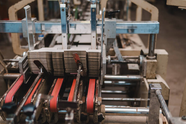 The line of assembly of cardboard packaging in boxes and finished products. Mechanism and production industry