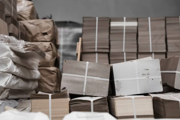 pallets with boxes, products are packed in paper and stacked in piles at the finished goods warehouse. Cardboard factory concept. Selective focus