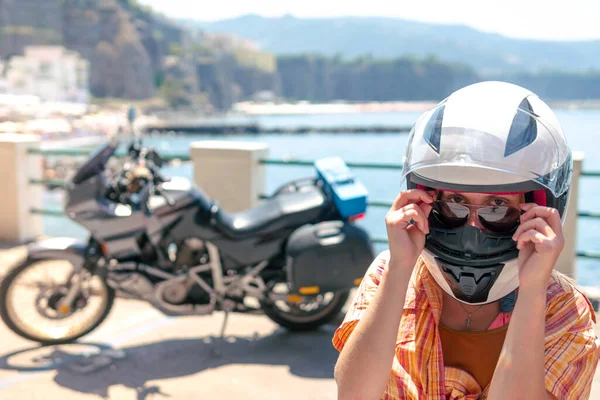 포즈를 취하는 선글라스 관광과 여행을 오토바이 헬멧을 배경에는 바다와 보인다 — 스톡 사진