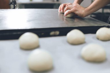 Adam hamuru yoğuruyor. Hamburger çörekleri. Fırın, üretim. Uzayı kopyala Seçici odak