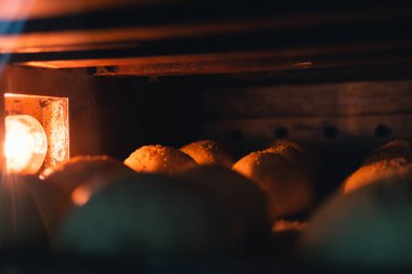 Hamburger çörekleri fırında. Endüstriyel fırın Fırın, kendi üretimi. Karanlık tema. Seçici odak / Soace Kopyala